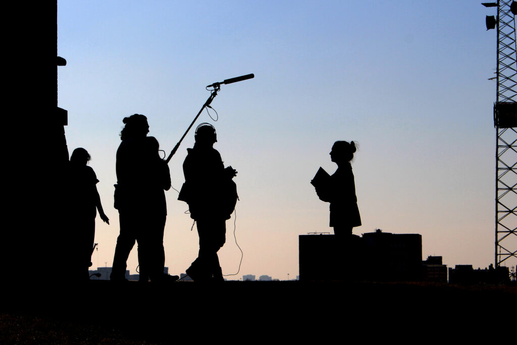 Silhouette of film crew with boom microphone