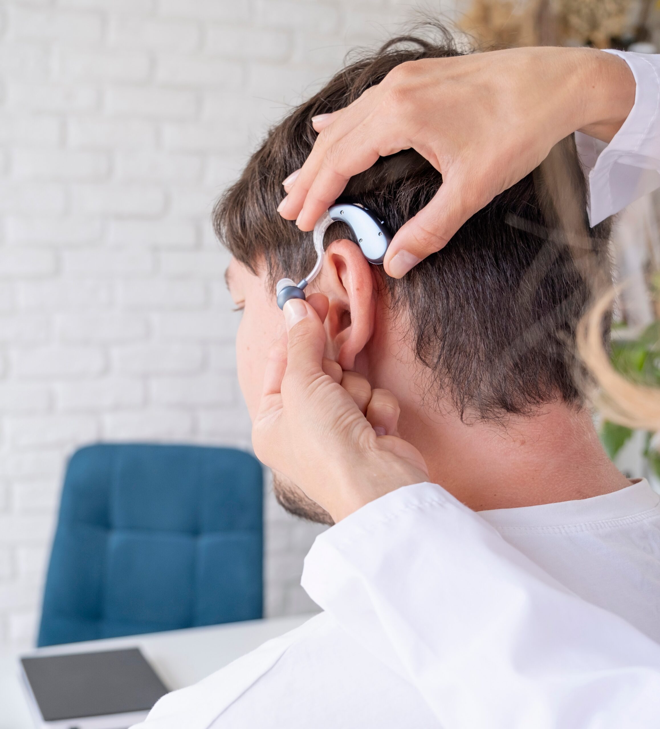 patient testing hearing aid in clinic exam room